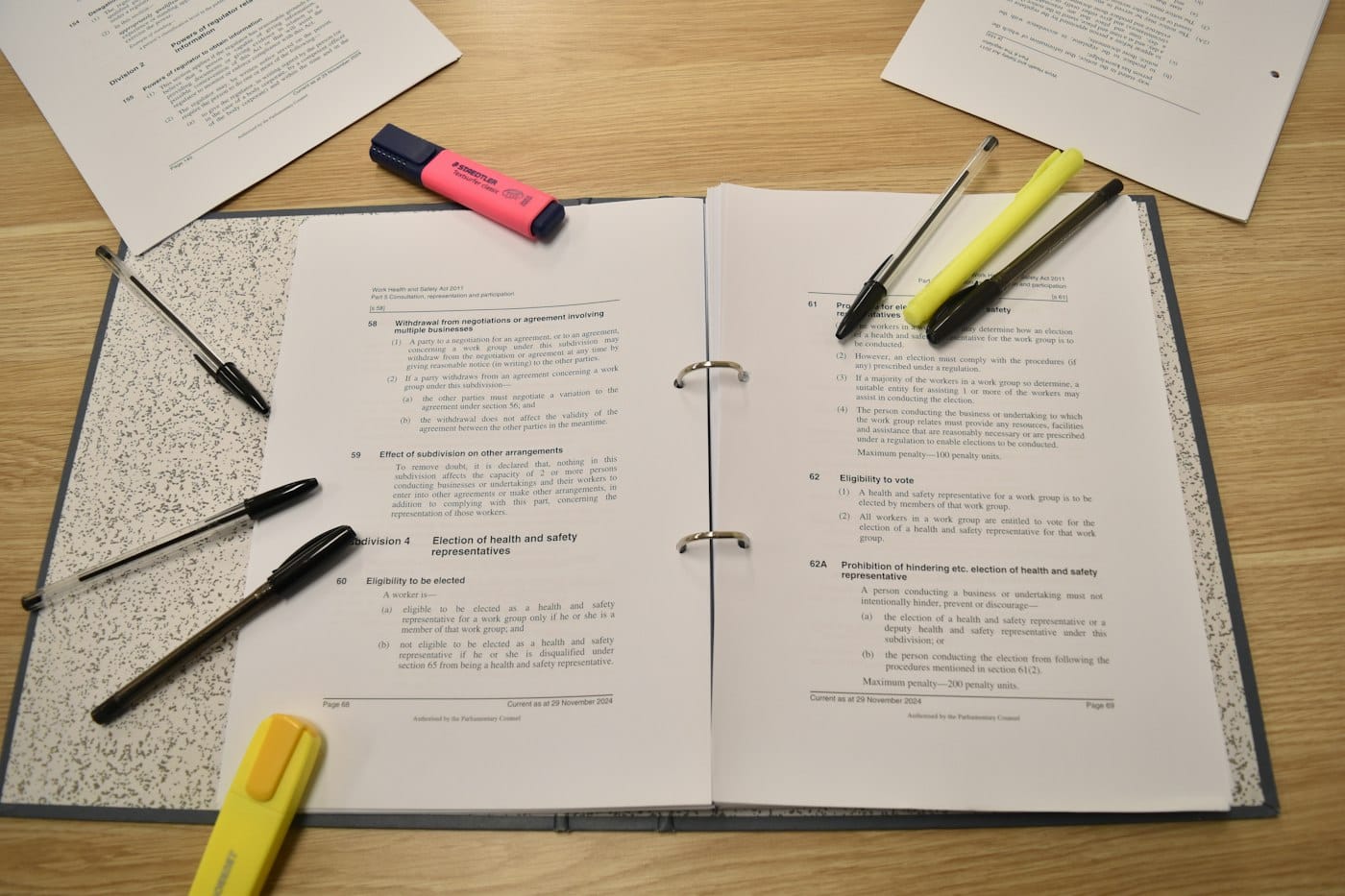 Open ring binder of legislation with pens and highlighters