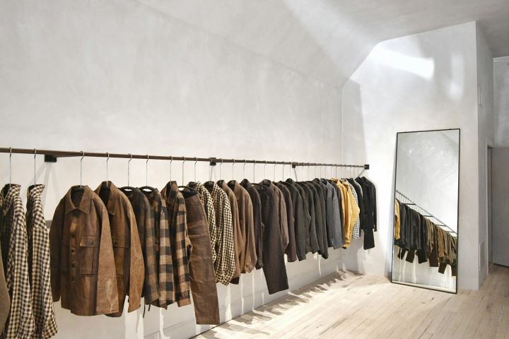 Boutique clothing rail Minimal boutique interior with a rail of jackets and a tall mirror
