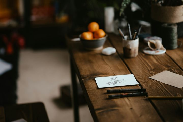 Designer worktable sketch Designer’s timber worktable with a botanical sketch, fine-liner pens and a bowl of oranges