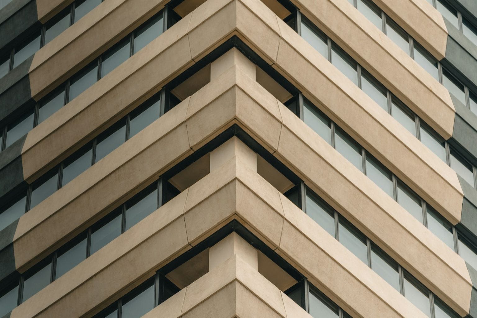 Looking up at the stepped sandstone-coloured facade of an office tower in the Melbourne CBD