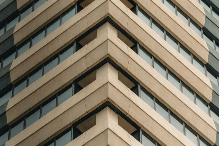 Looking up at the stepped sandstone-coloured facade of an office tower in the Melbourne CBD