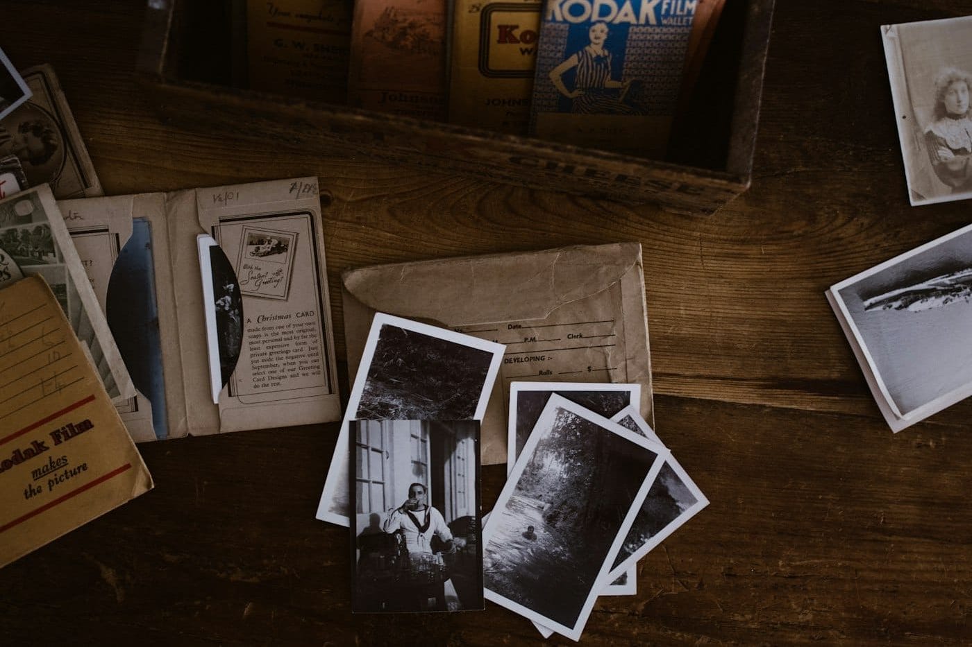 Old family photographs and cards spread on a timber table