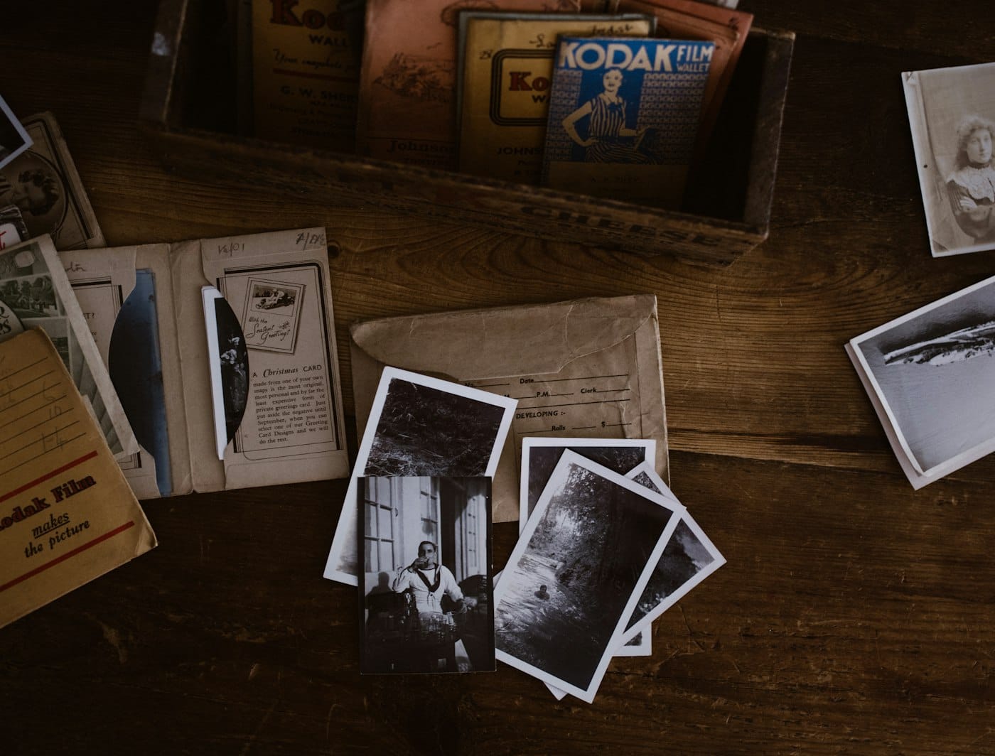 Old family photographs and cards spread on a timber table