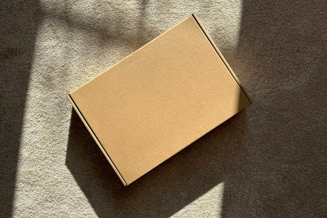 Plain cardboard delivery box in afternoon sunlight