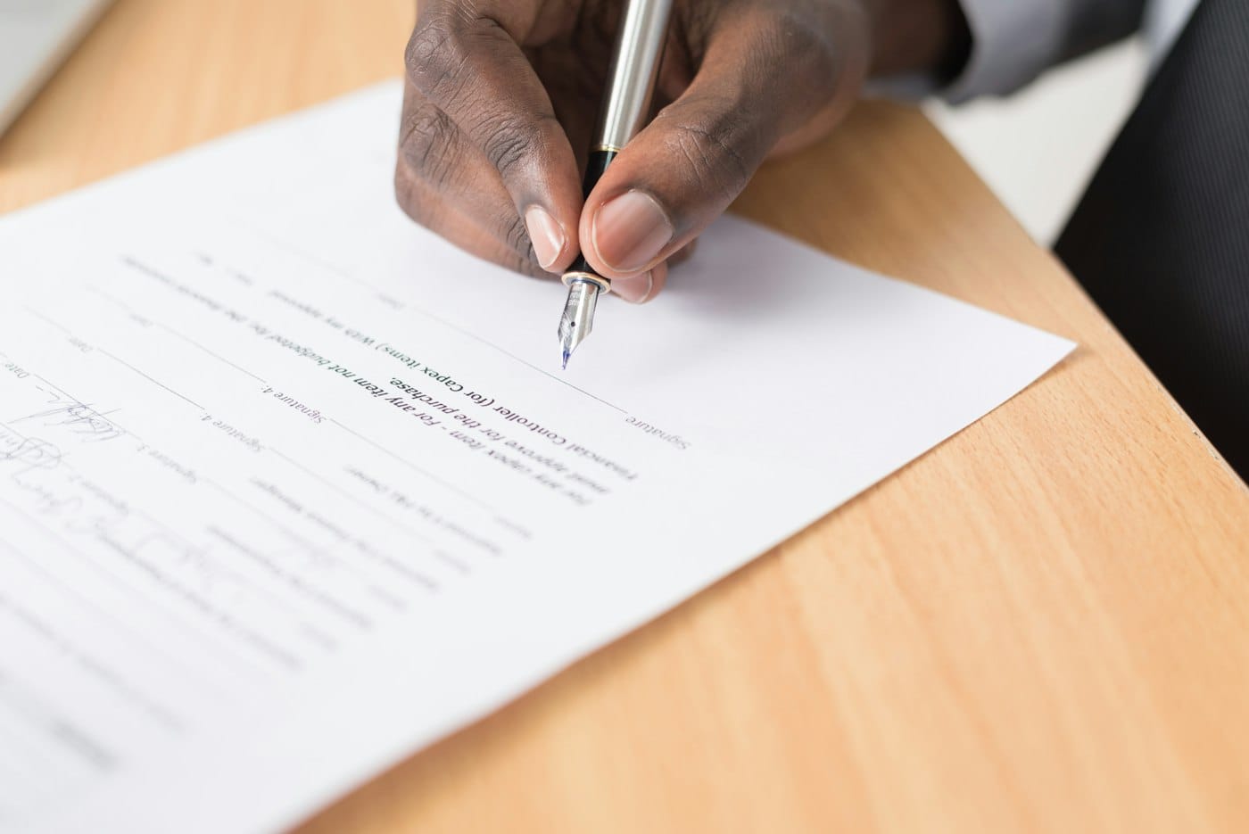 Hand signing a contract with a fountain pen