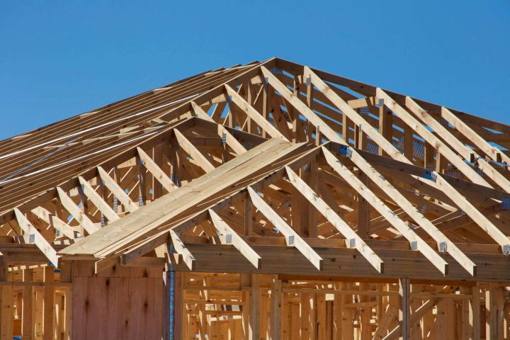 Timber roof trusses Timber roof trusses of a new house against a clear blue sky